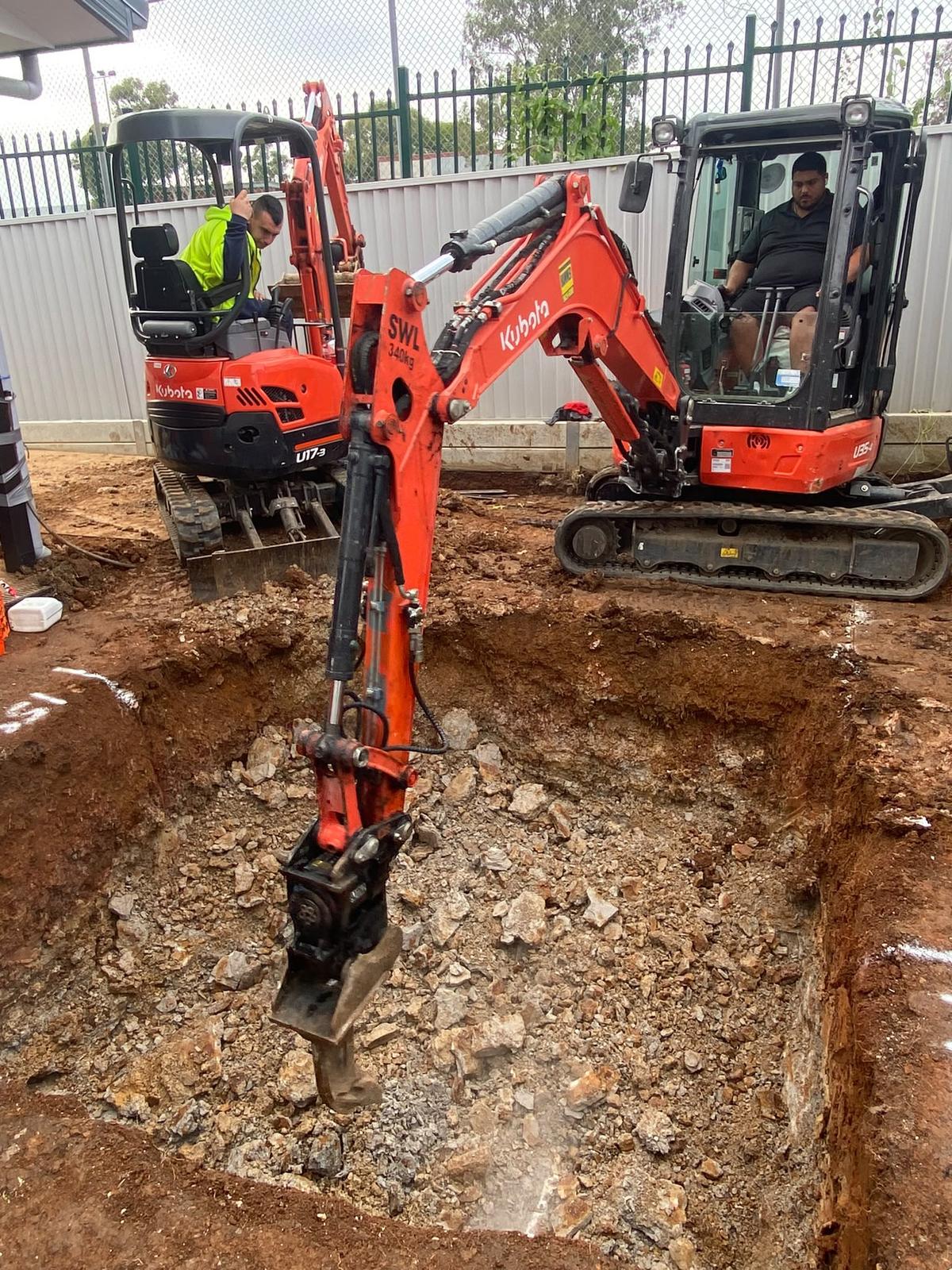 Two mini excavators digging footings on a residential job